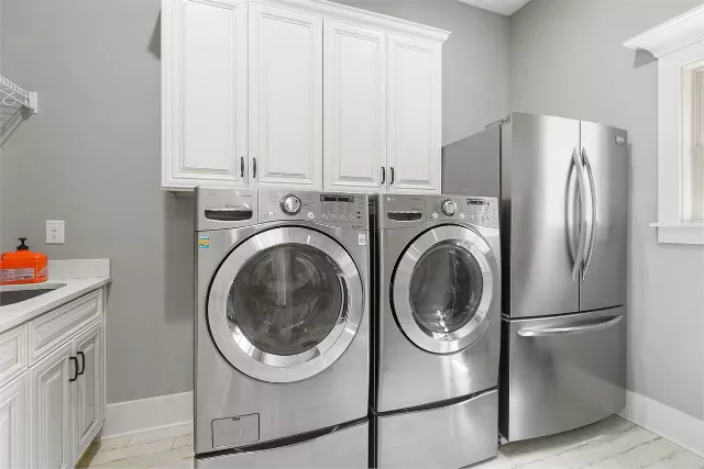 Classic cottage laundry room features a white and gray granite